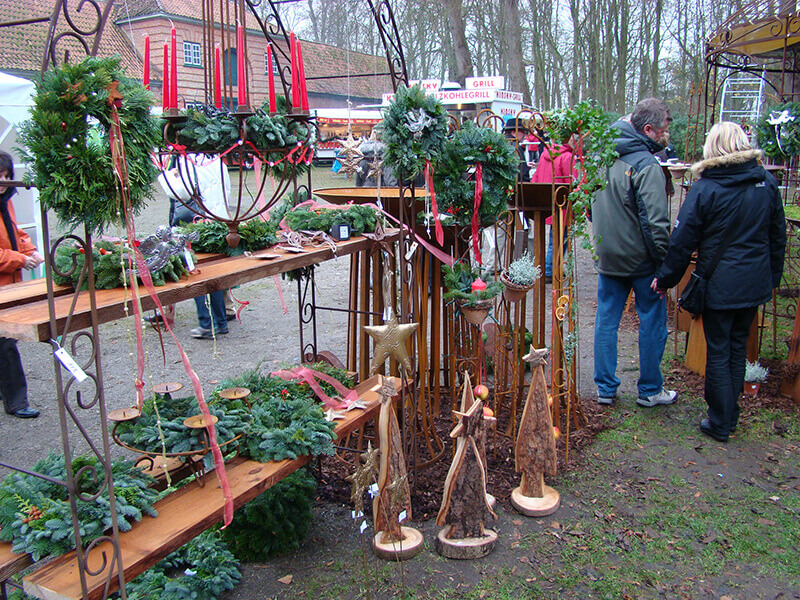 Archivmotiv von Gut Emkendorf: Weihnachtlicher Grünschmuck und Dekoration an einem Marktstand.