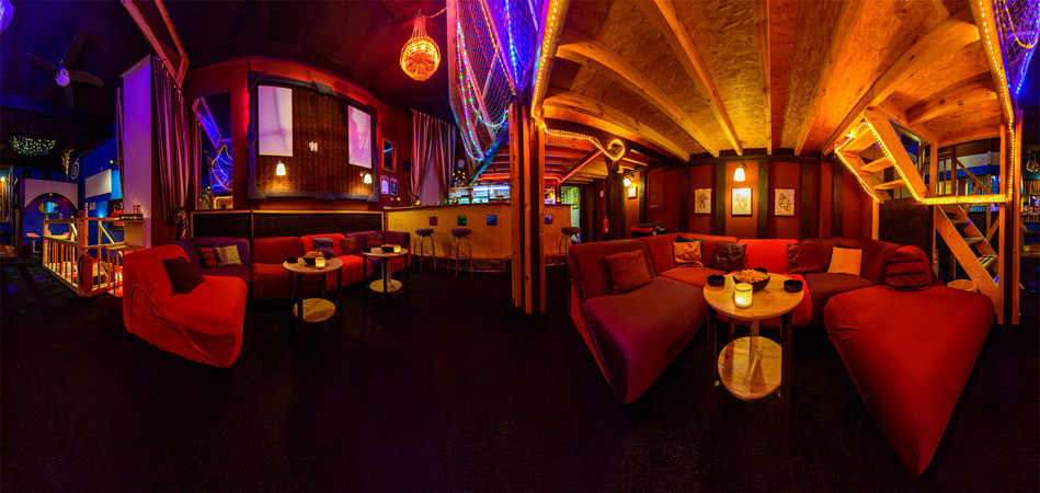 Warme Beleuchtung, Sofas und kleine Tische in der Ajpnia-Lounge.