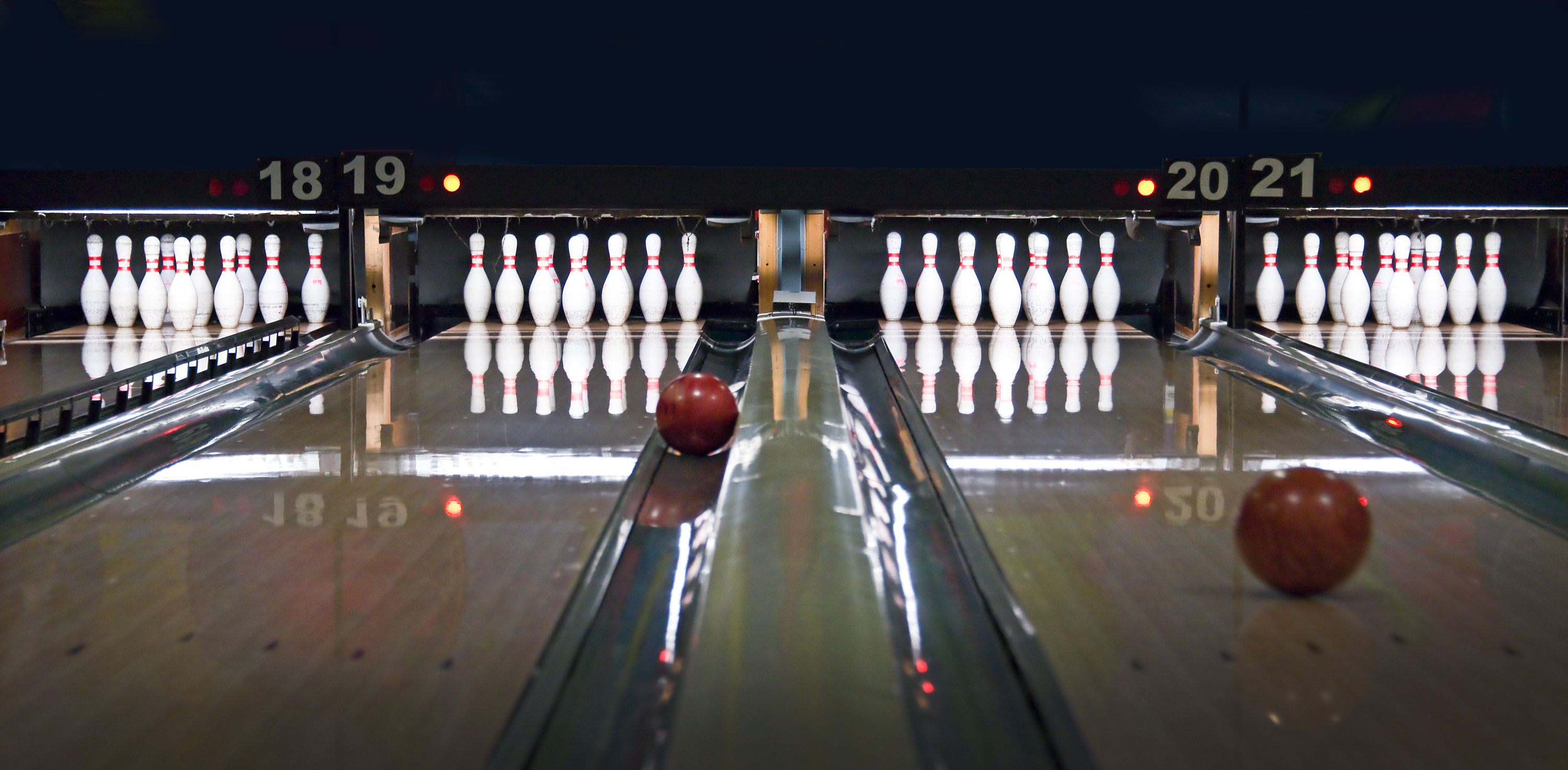 Bowlingbahnen mit aufgestellten Pins und rollenden Kugeln – Symbolbild für den MLC-Abend.