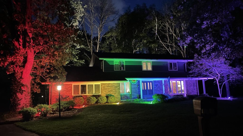 Zwei Männer nutzen bunte Flutlichter für ihr Pride Home