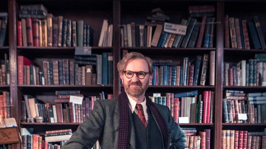 Mark Gatiss als Gabriel Book vor den Bücherregalen seines Antiquariats in „Bookish“.