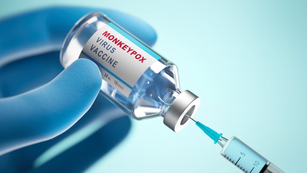 Symbolische Darstellung einer behandschuhten Hand mit Impfstofffläschchen und Spritze zum Thema Mpox-Impfung.
