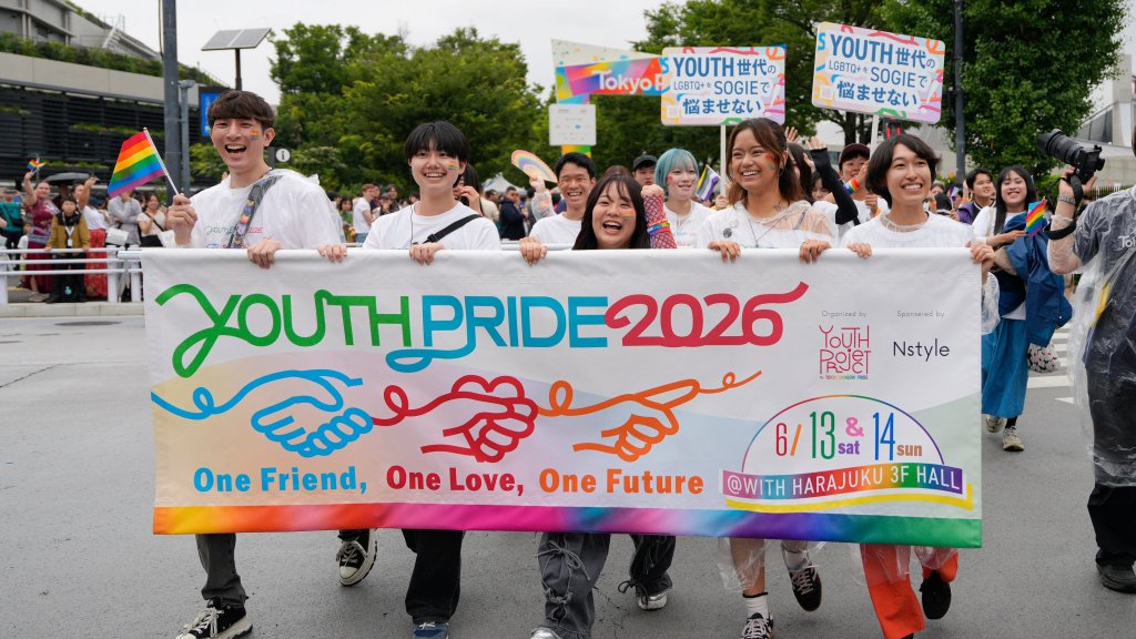 Teilnehmende der Tokyo Pride 2026 tragen ein buntes Youth-Pride-Banner und Regenbogenfahnen durch Tokio.