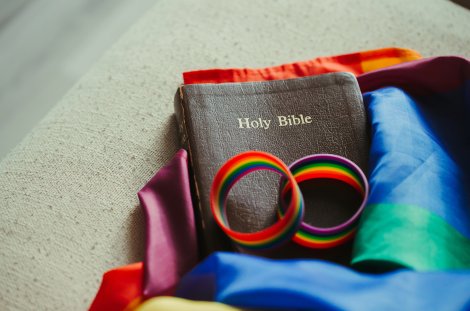 Bibel mit Regenbogenfahne und Regenbogenarmbändern (Symbolbild)