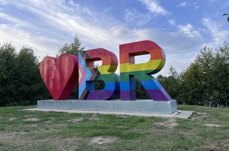 Große Buchstaben BR in Regenbogenfarben mit einem roten herz davor.