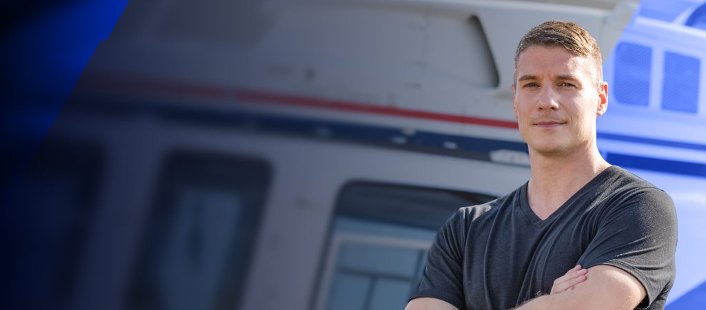 Chris Gallant steht mit verschränkten Armen vor einem Feuerwehrfahrzeug.