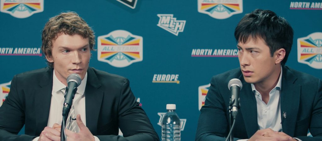 Connor Storrie und Hudson Williams als Ilya und Shane bei einer Pressekonferenz in Heated Rivalry (Szenenbild).