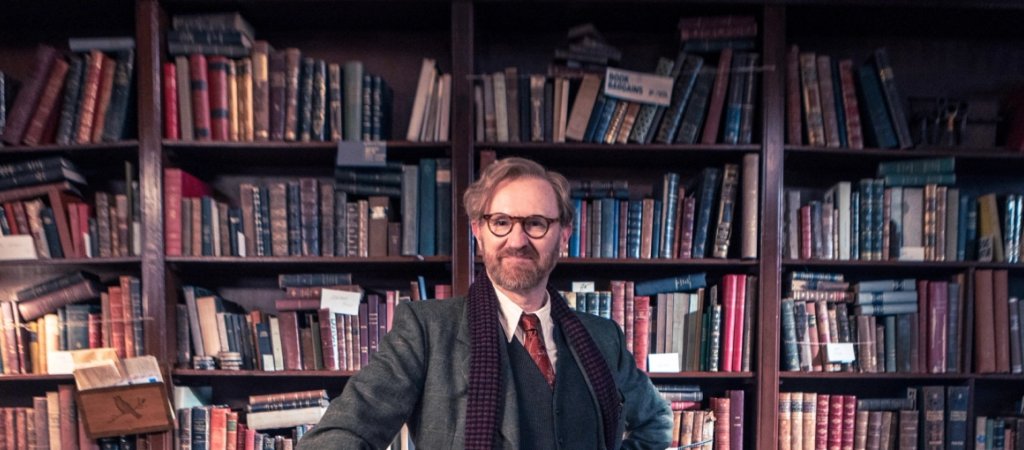 Mark Gatiss als Gabriel Book vor den Bücherregalen seines Antiquariats in „Bookish“.