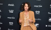 Ulrike Folkerts im karierten Hosenanzug bei einem Fototermin auf dem roten Teppich