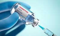 Symbolische Darstellung einer behandschuhten Hand mit Impfstofffläschchen und Spritze zum Thema Mpox-Impfung.
