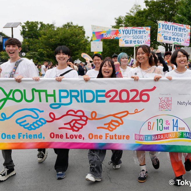 Teilnehmende der Tokyo Pride 2026 tragen ein buntes Youth-Pride-Banner und Regenbogenfahnen durch Tokio.
