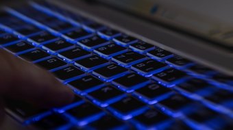 Symbolbild: Finger auf einer beleuchteten Laptop-Tastatur.