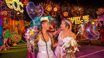 Zwei Frauen mit Blumensträußen und Herzballons bei einem nächtlichen Festival in Las Vegas