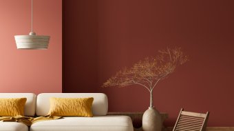 Wohnzimmer mit dunkelroter Wand und warmen Farbakzenten
