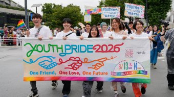 Teilnehmende der Tokyo Pride 2026 tragen ein buntes Youth-Pride-Banner und Regenbogenfahnen durch Tokio.