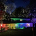 Zwei Männer nutzen bunte Flutlichter für ihr Pride Home