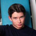 Stephen Gately in einem dunklen Calvin-Klein-T-Shirt vor türkisfarbenem Hintergrund