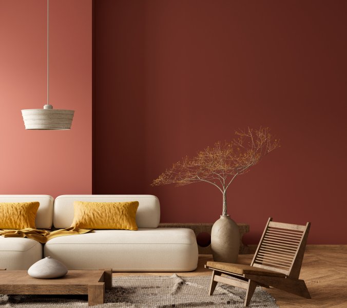Wohnzimmer mit dunkelroter Wand und warmen Farbakzenten