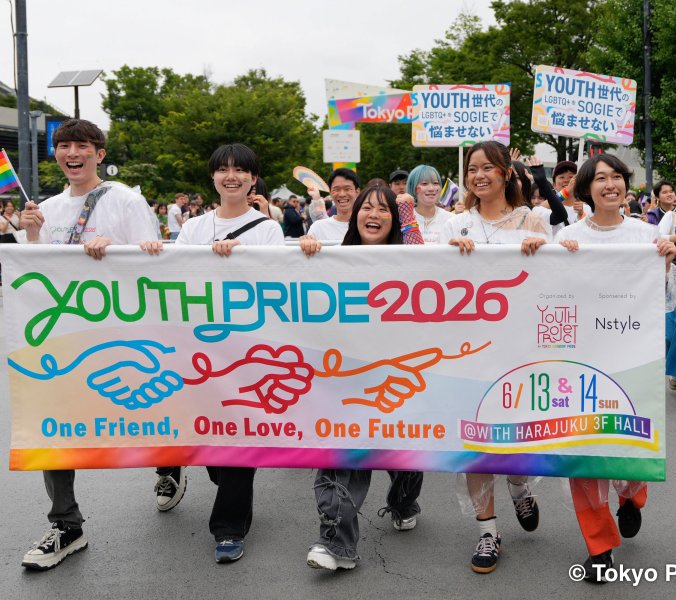 Teilnehmende der Tokyo Pride 2026 tragen ein buntes Youth-Pride-Banner und Regenbogenfahnen durch Tokio.
